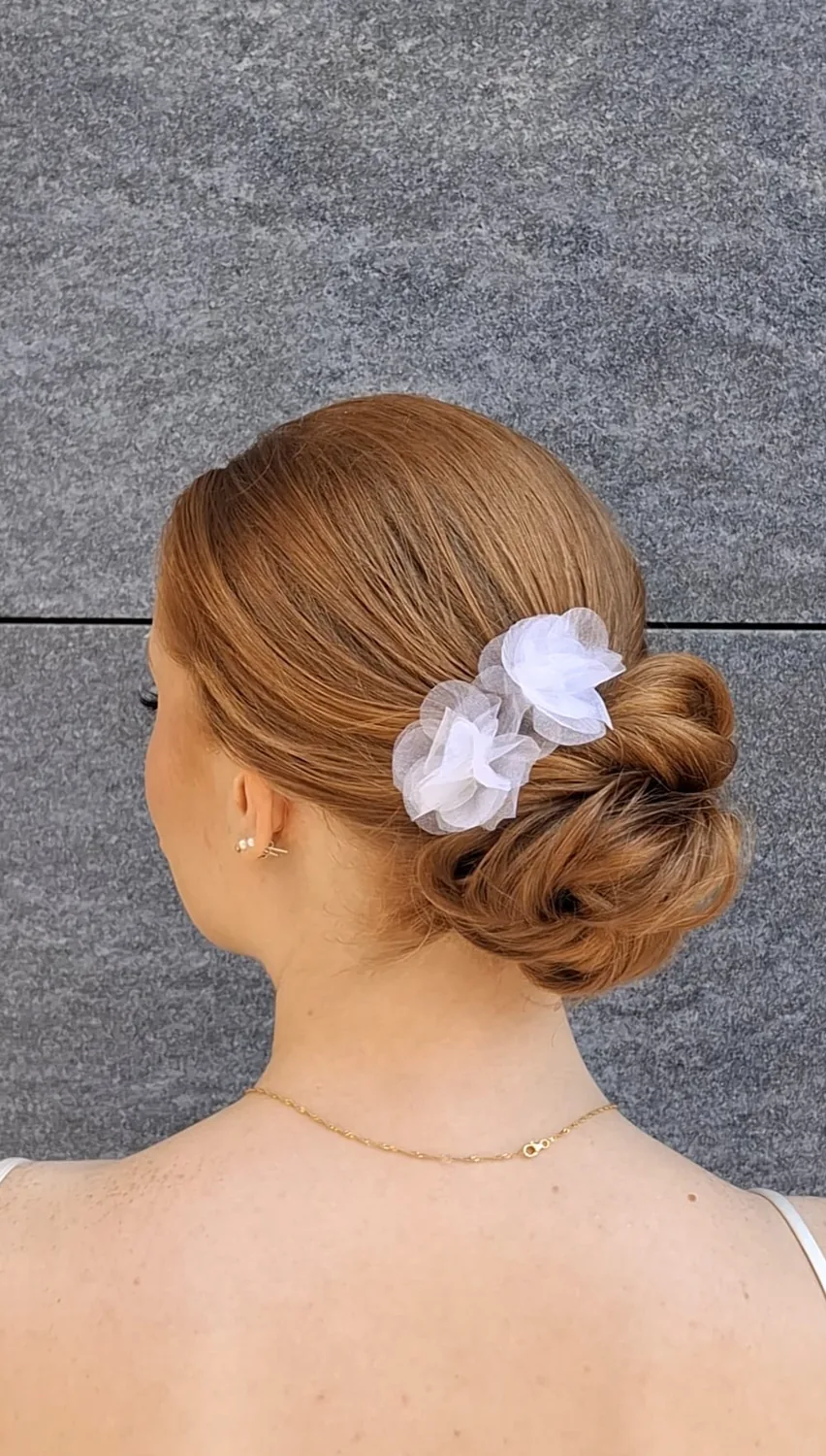 Eleganter tiefer Chignon mit weissem Haarschmuck von hinten
